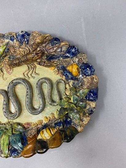 null Enameled earthenware dish with molded relief decoration representing a snake,...