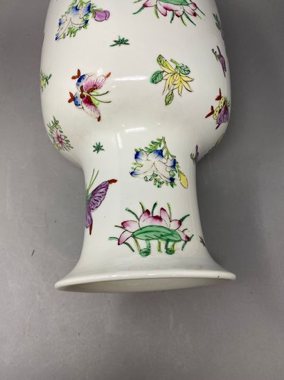 Un vase Chine fond blanc, à décor de semi de fleurs et de papilllons polychromes...