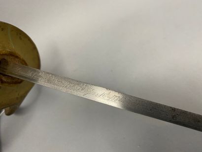 Une épée dans son fourreau en cuir, lame gravée 1885-1882 Une épée dans son fourreau...