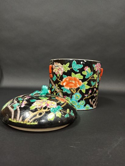 Pot couvert en porcelaine à décor de fleurs et papilons flanqué de deux anses sur les côtés.