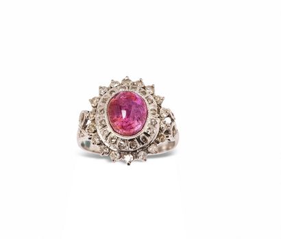 null 18K (750) white gold ring, set with a cabochon ruby surrounded and shouldered...
