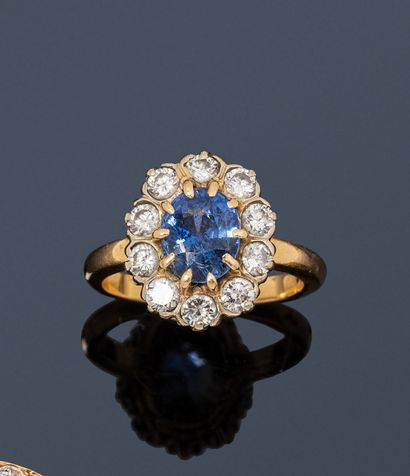 null 18K (750) gold ring, set with an oval sapphire surrounded by round brilliant-cut...