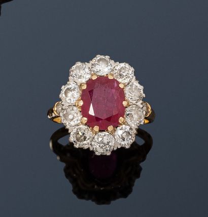 null 18K (750) gold ring, set with an oval ruby surrounded and shouldered by old-cut...