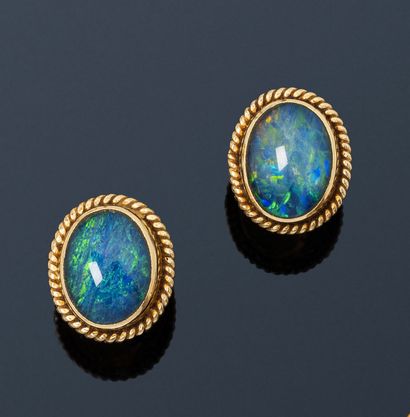 null Pair of 18K (750) gold earrings, each adorned with a cabochon opal surrounded...
