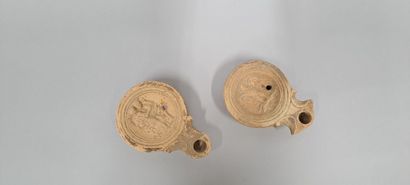 null Lot of two oil lamps with scroll spout. The medallions are decorated with an...