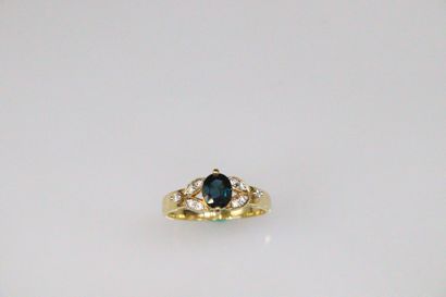 null 18K (750) yellow gold ring set with an oval synthetic sapphire surrounded by...