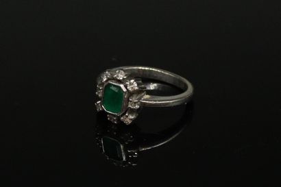 null 14k (585) white gold ring set with an emerald in a circle of small diamonds.
Finger...