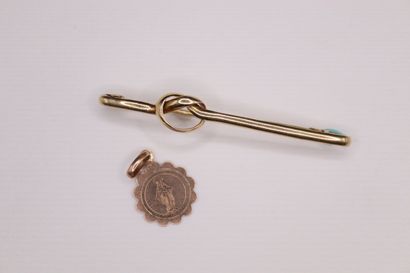 null Brooch in 18k (750) yellow gold forming a knot.
A small baptismal medal in 18k...