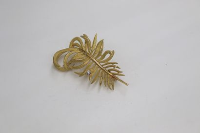 null Brooch in 18K (750) yellow gold stylizing a branch with amaties leaves decorated...