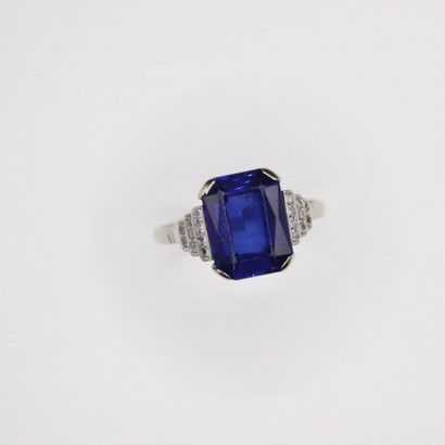null 18K (750) white gold ring set with a synthetic sapphire and rows of diamonds....