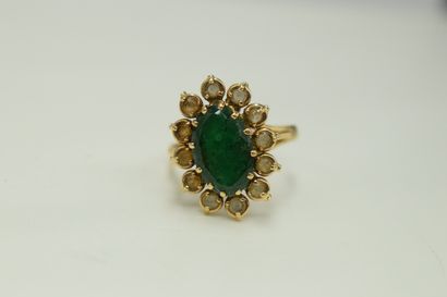 null 18K (750) yellow gold daisy ring set with an oval emerald in a circle of white...
