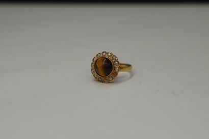 null 18K (750) yellow gold ring set with a tiger's eye cabochon in a circle of small...