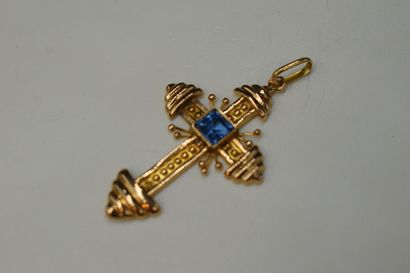 null Cross in 18K (750) yellow gold centered with a blue stone. 
Weight : 2.2 g....