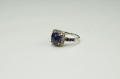 null 9k (375) white gold ring set with a faceted blue stone surrounded by a pavement...