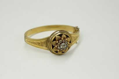 null 14K (585) yellow gold band with a chased plant decoration and a flower decorated...
