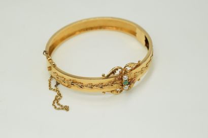 null Bracelet en or jaune 18K (750) à décor de fleurons et de rinceaux orné de deux...