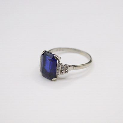 null 18K (750) white gold ring set with a synthetic sapphire and rows of diamonds....
