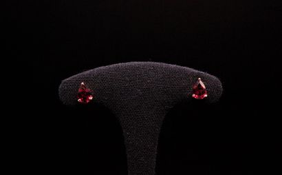 null Pair of 925° pink vermeil ear studs each holding a pear-shaped garnet in claw...