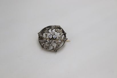 null Broche circulaire en or gris 18K (750) à décor végétal ornée de trois diamants...