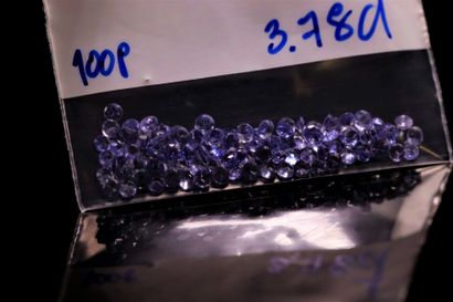Mix of one hundred round tanzanites on paper....
