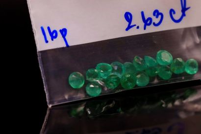 Mixture of sixteen round emeralds on paper....