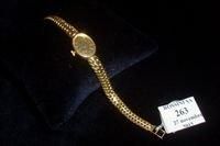 FLAMAND Montre bracelet de dame ovale en or jaune 18K (750/1000e). Cadran doré index...