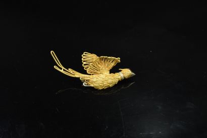 null 18k (750) yellow gold bird brooch with textured gold strands, the eye adorned...