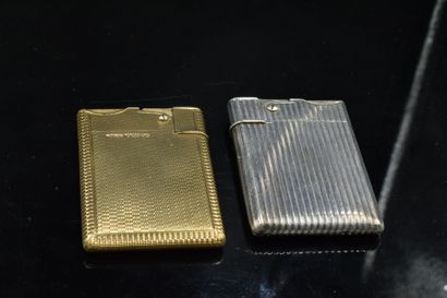 null Set of two lighters : 
- a 9K (375) yellow gold lighter with guilloché decoration
Gross...