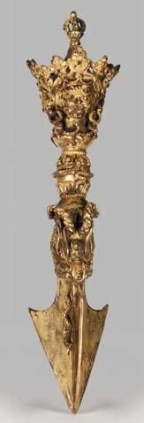 null Phurbu en bronze doré, dont la lame tripartite est crachée par une tête de dragon...