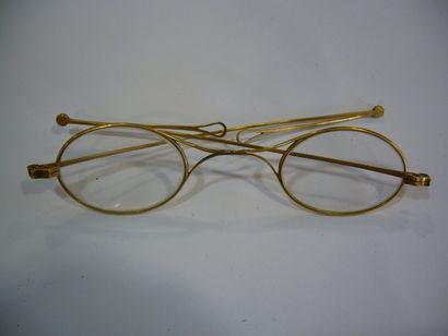 null paire de lunettes verres ovales, branches aux extrêmité pliantes monture or...