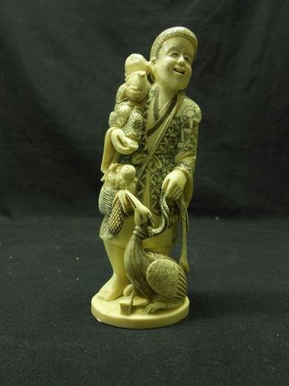 ASIE Okimono en ivoire, figurant un homme portant un enfant, à ses pieds un volatile....