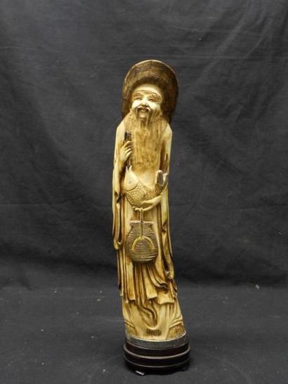 ASIE Sujet en ivoire teinté représentant un dieu du Tao tenant un poisson et un panier,...