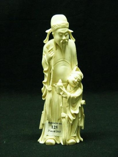 null Sujet en ivoire représentant un dieu du Tao accompagné d'un enfant tenant une...