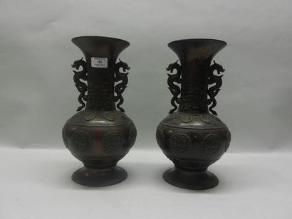 ASIE Paire de vases balustres en bronze à col évasé à décor en macarons de dragons....
