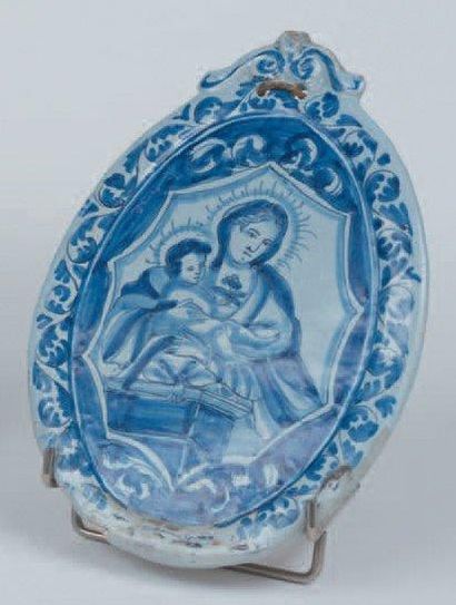 NEVERS Plaque ovale à décor en camaïeu bleu d'une Vierge à l'Enfant et d'une guirlande...