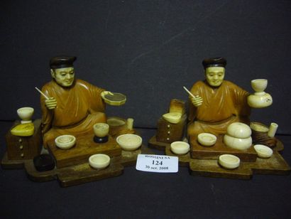 null Deux okimono en bois et ivoire, représentant des marchands ambulants assis devant...