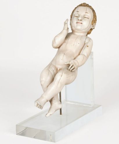 null Enfant Jésus en ivoire sculpté. Il est allongé, semble endormi, la main droite...