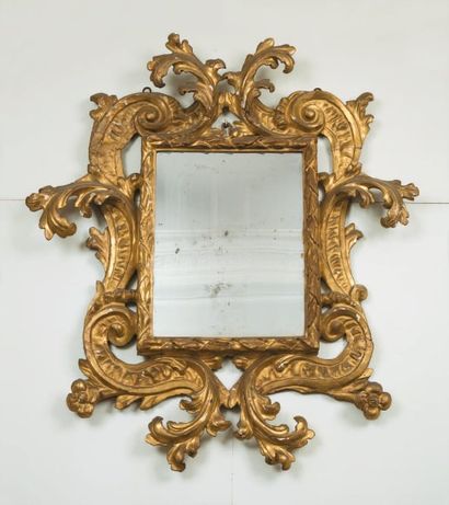 null Miroir dans un cadre en bois sculpté et doré. Travail italien du XVIIIe siècle....