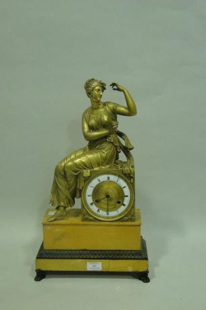 null Pendule en bronze doré figurant une femme vêtue à l'antique assise sur une borne...