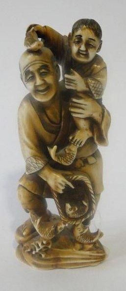 null Okimono en ivoire représentant un pêcheur portant son fils sur son épaule. Japon,...