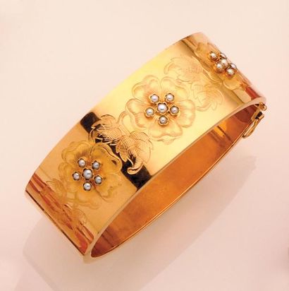 null Bracelet «Jonc» plat en or jaune, la partie supérieure à décor floral ciselé...