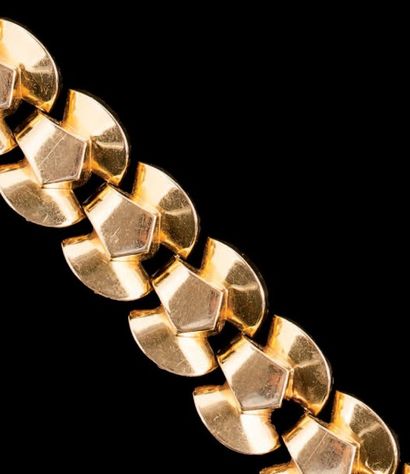 null Bracelet large en or jaune (750) articulé de quarts de ronds et d'agrafes àpans.
Epoque...