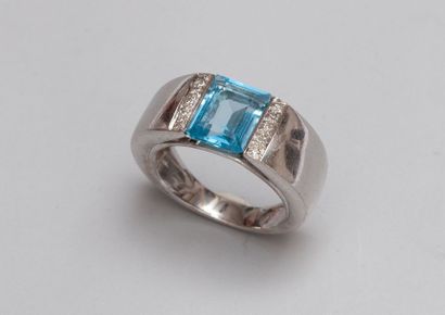 null Bague en or gris 18ct (750) sertie d'une topaze bleue entre deux lignes de diamants...