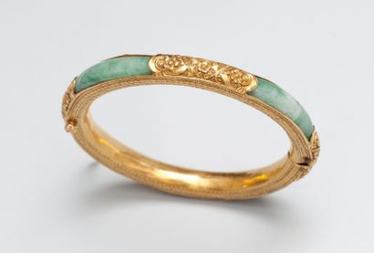 null Bracelet rigide ouvrant en jade et or jaune 18 ct (750) ciselé de fleurs.
Tour...