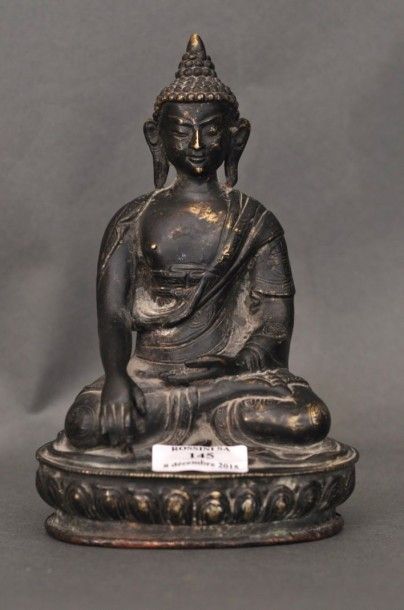 null Bouddha en bronze de patine brune, assis en méditation sur un lotus, les mains...
