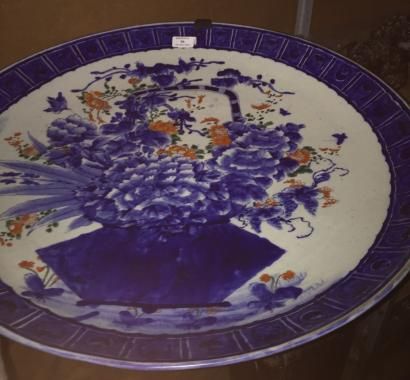 null Grand plat en porcelaine à décor en bleu rehaussé de polychromie, représentant...
