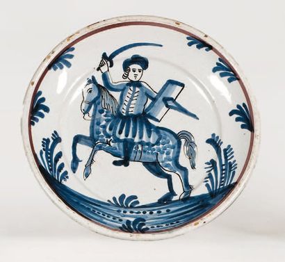 Hesdin Plat rond à décor en camaïeu bleu au centre d'un cavalier sur un cheval, brandissant...