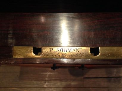 SORMANI P. Table de style en bois de placage, le plateau chantourné gainé de bronzes....