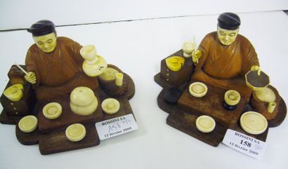 null Deux okimono en bois et ivoire, représentant des marchands ambulants assis devant...