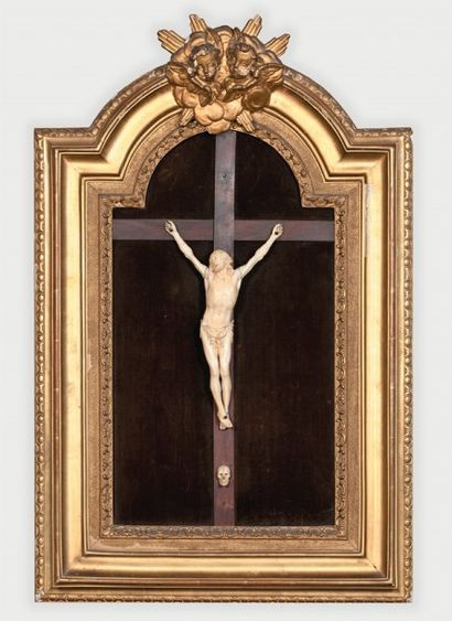 null Crucifix en ivoire encadrement cintré en bois sculpté et doré orné de deux têtes...